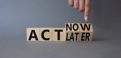 Act Now vs Act Later symbol. Businessman hand points at cubes with words Act Now vs Act Later. Beautiful grey background. Business concept. Copy space
