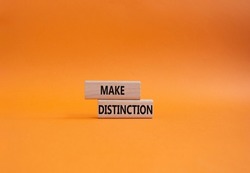 Make distinction symbol. Concept words make distinction on wooden blocks. Beautiful orange background. Business and make distinction concept. Copy space.