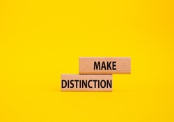 Make distinction symbol. Concept words make distinction on wooden blocks. Beautiful yellow background. Business and make distinction concept. Copy space.