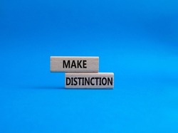 Make distinction symbol. Concept words make distinction on wooden blocks. Beautiful blue background. Business and make distinction concept. Copy space.