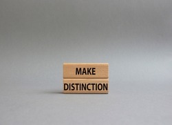 Make distinction symbol. Concept words make distinction on wooden blocks. Beautiful grey background. Business and make distinction concept. Copy space.