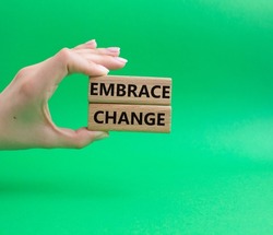 Embrace change symbol. Concept word Embrace change on wooden blocks. Beautiful green background. Businessman hand. Business and Embrace change concept. Copy space
