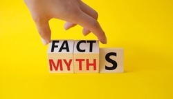 Facts vs Myths symbol. Businessman Hand turns cubes and changes word Myths to Facts. Beautiful yellow background. Business and Facts vs Myths concept. Copy space