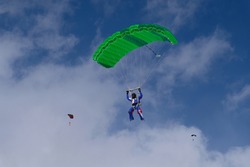 Skydiving. A skydiver is flying a parachute in the blue sky.