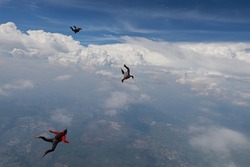 Skydiving. Skydivers are flying in the sky.