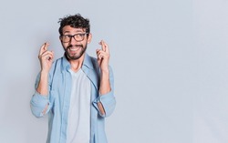 Concept of positive person making a wish and crossing his fingers on isolated background. Positive people smiling making a wish while crossing his fingers. Happy man making a wish crossing his fingers