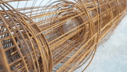 Rusted wire reels for concrete floors climbing tall buildings. Rebar construction material. Iron net of wire for industrial usage. Reinforcing steel for concrete