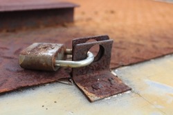 an old rusty padlock on a rusty iron plate