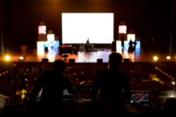 Blur image of sound engineers and technician team working to prepare and setup equipment for the music concert stage. The concept behind the working of event crews.