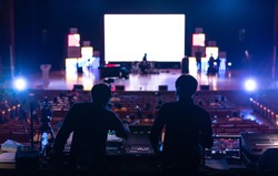 Blur image of sound engineer backstage crew team working to setting and preparing production for show events or music concert stage with blurry white screen in background.