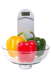 Bell peppers on a electronic kitchen scale, isolated on white background