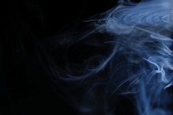 Graceful swirls of blue smoke isolated from black background. Close-up of vapor. Soft focus and texture from vintage Helios 44m-4 lens. Abstract graphic design asset. Horizontal copy space.
