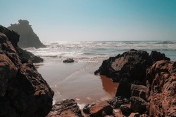 Rugged landscape of Aftas Beach in the chill coastal town of Mirleft, Morocco. Landmark popular with surfers, locals, and tourists. Atlantic Ocean waves. Summer day. Empty shore. Travel background.