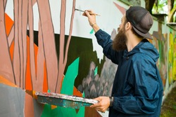 The artist draws graffiti.