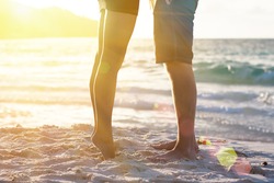 Young couple legs on the beach sand. Travel summer tropic holidays. Sunset silhouette of kissing newlyweds lovers hugging in front of ocean. Honeymoon vacation romantic sea view on Seychelles islands