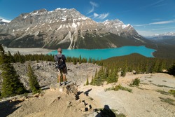 a tourist standing on a cliff looking down to Peyto Lake in Alberta,Canada