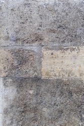 Close up of rough, weathered stone block wall. Shows four blocks in a symmetrical configuration. The two middle blocks are smaller. Ideal for abstract design backgrounds.