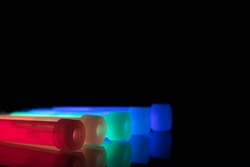 Colourful glowsticks on a reflective surface