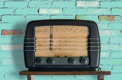 Vintage radio with wooden body over colorful retro background 