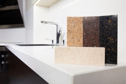 Different quartz kitchen counter top samples on white polished countertop with precise processed edges.
