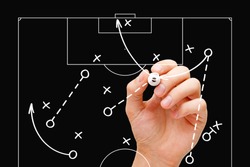 Coach drawing soccer play tactics with white marker on transparent wipe board over black background. Football manager explaining game strategy.