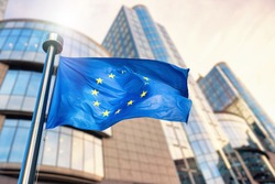 EU flag waving in front of European Parliament building. Brussels, Belgium