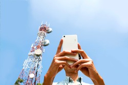 
Man using smart phone devices with Telecommunication tower  blue sky background