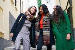 Multiethnic group of three happy woman walking together outdoors