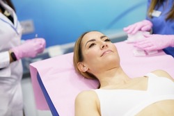 Middle-aged woman lying on the stretcher in an aesthetic clinic waiting for a botulinum toxin treatment.