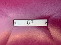 a maroon waiting chair with seat number 