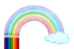 Colored pencils with hand drawing of rainbow and cloud