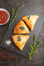 Homemade asian pastry samosa on black concrete background. top view, flat lay, close up.