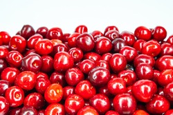 Heap of ripe red sweet cherries on a white background.