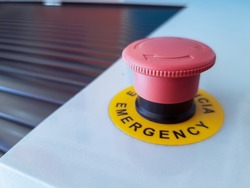 Red emergency button with writing indicating emergency

