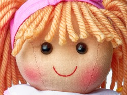 Closeup face rag doll smiling on a white background