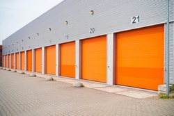 exterior of a commercial warehouse with orange roller doors