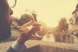 Young man drinking wine outdoors.