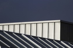 Metal and glass roof of industrial building. Modern architecture. Hi-tech material geometric structure. Angular geometric pattern. Parallel lines. Close-up photo of urban scene. Construction industry.