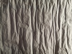 Crumpled paper. Grunge wallpaper pattern with irregular structure. Decorative abstact material background with natural texture, lights and shadows, fissures, cracks and wrinkles. Modern grahic design.