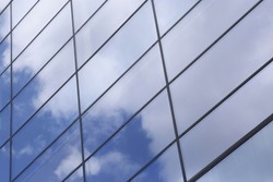 Glass architecture. All-over glazing structure with sky reflection. Close-up fragment of business cityscape.