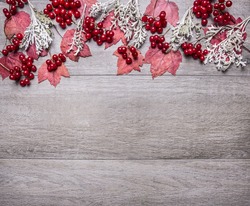 border with red maple leaves, viburnum berries and autumn scenery on grey wooden rustic background top view close up with text area