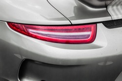Tail light of sport grey car with rain drops and shadows. Closeup headlights of car. Modern luxury car close-up banner background. Concept of expensive, sports auto Closeup headlights Porsche 911