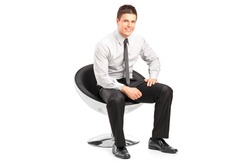 A young handsome malesitting on  chairand posing isolated on white background