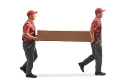 Full length profile shot of two movers carrying a big cardboard box isolated on white background