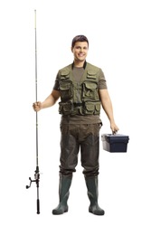 Full length portrait of a young fisherman posing with a fishing rod and a case isolated on white background