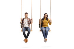Full length portrait of a male and female teenage students sitting on a swing isolated on white background