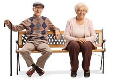 Seniors smiling and sitting on a bench isolated on white background