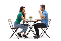 Young man and woman sitting a table and drinking coffee isolated on white background