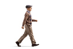 Full length profile shot of an elderly man walking fast isolated on white background