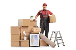 Professional mover posing with a pile of packed cardboard boxes ready for removal isolated on white background